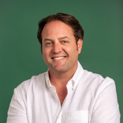 Nick Fairbairn, smiling man with short dark hair, wearing a white, collared, button-down shirt